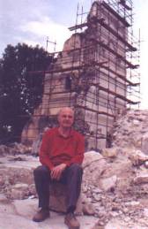 Milko Kelemen in front of the ruins of the Catholic church in Vocin destroyed during Greater Serbian agression on Croatia in 1991 (photo from www.viroviticko-podravska-zupanija.hr)